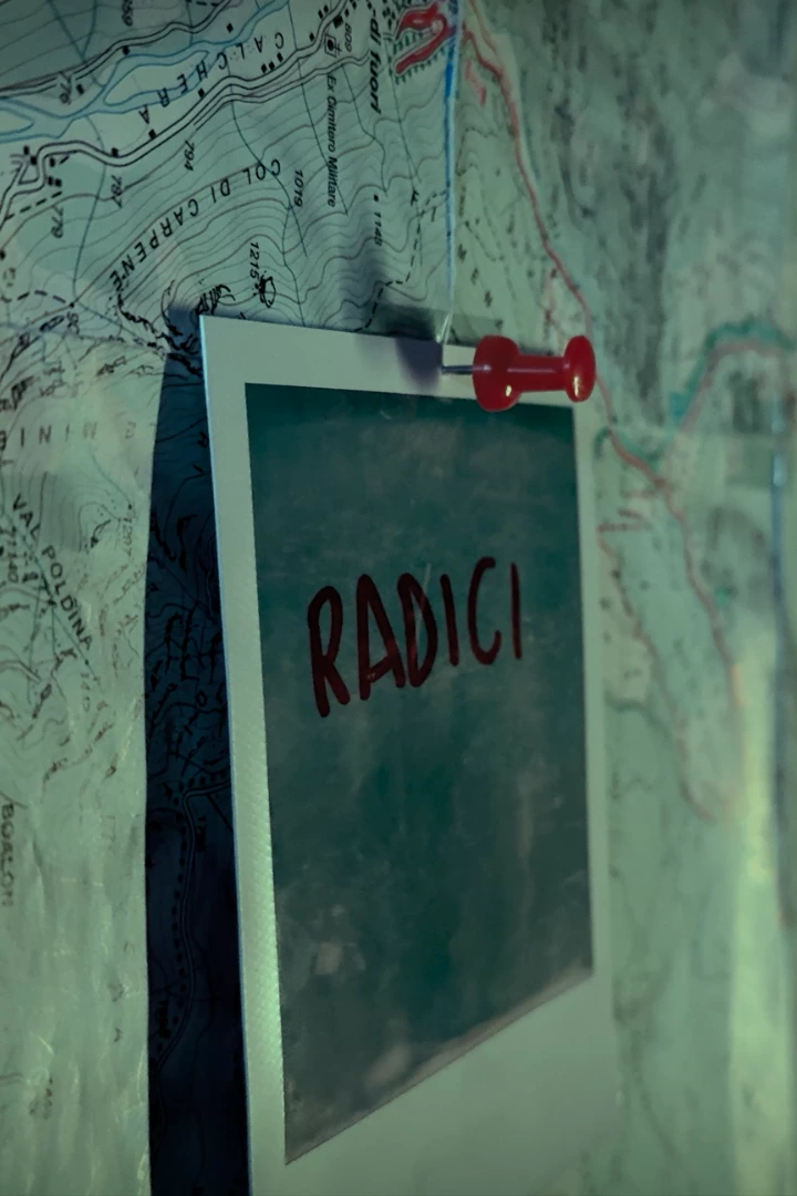 A pinned instant photograph marked Radici over a mountain map