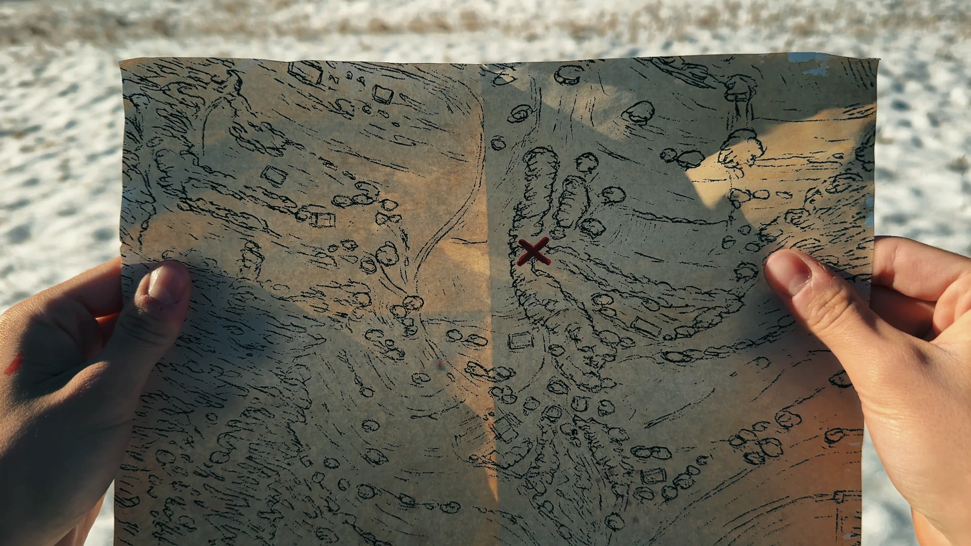Hands holding an illustrated map marked with a red X